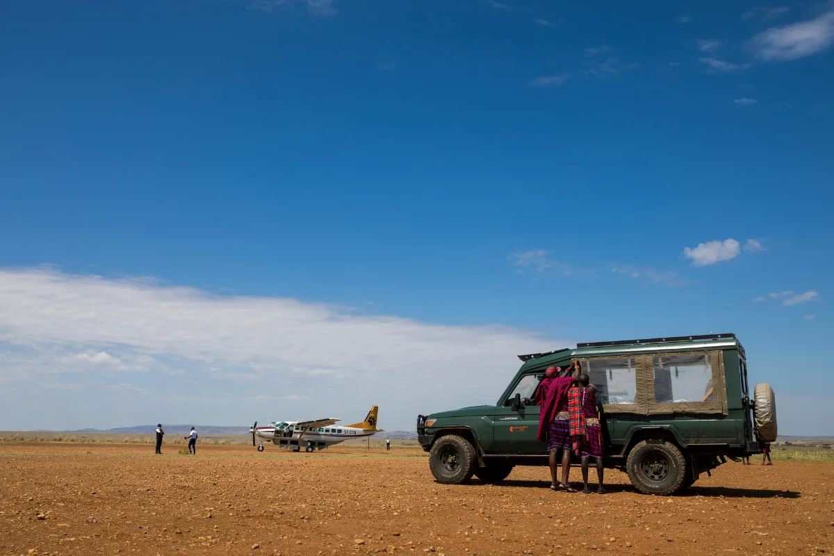 Safari vehicle and light aircraft at a remote Kenya bush airstrip